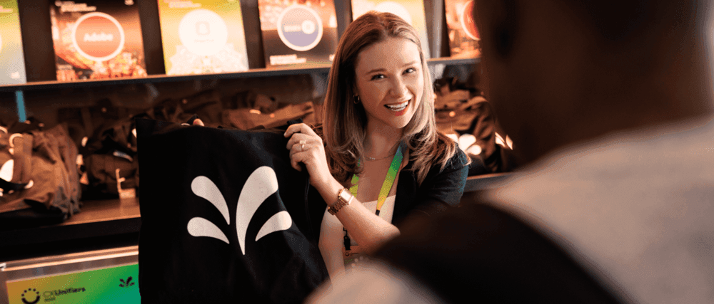 Person smiling and holding tote with Sprinklr burst